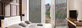 Moderne Vertikaljalousien vor großem Fenster mit Stadtblick